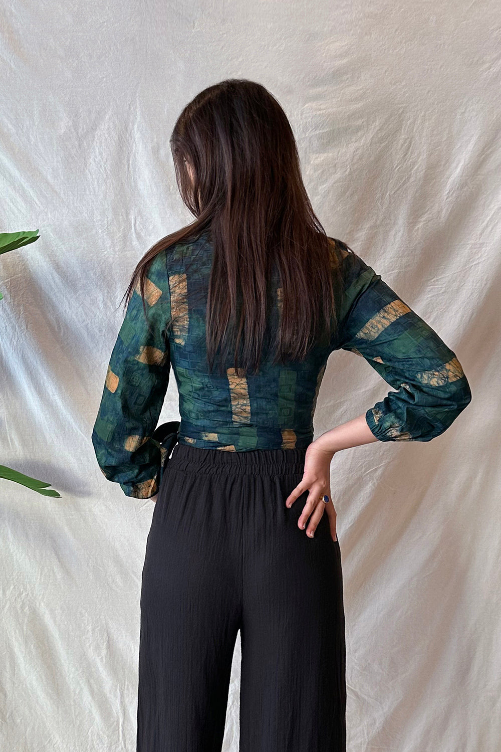 Back view of woman wearing navy hand-dyed batik Brush Strokes print long sleeve wrap top by GEOMETRIC. 