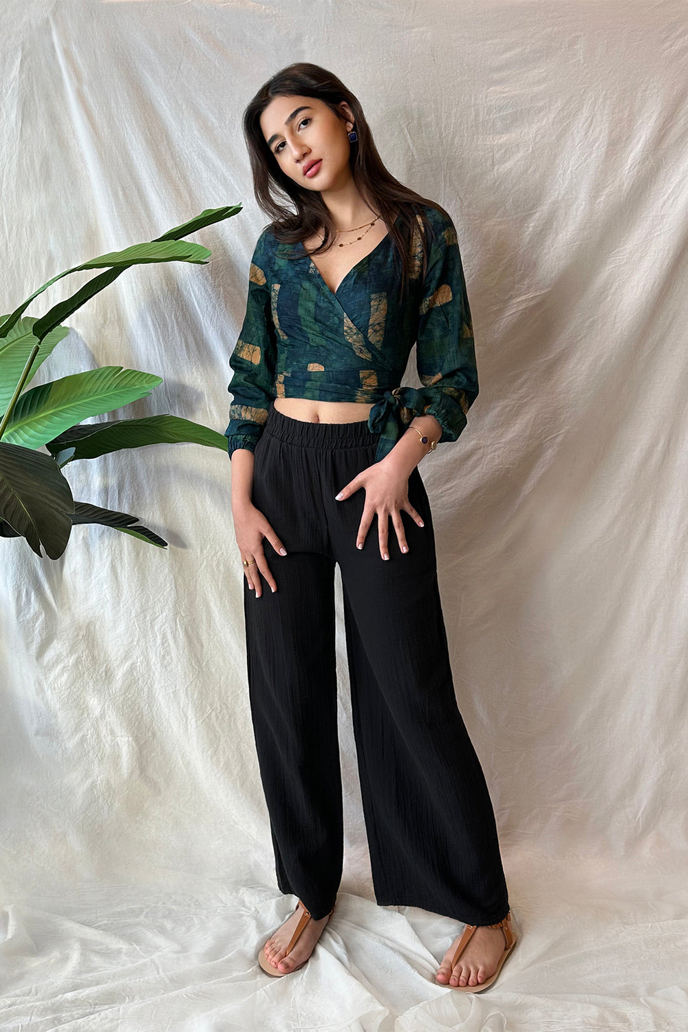 Woman wearing black pants and navy hand-dyed batik Brush Strokes print long sleeve wrap top by GEOMETRIC. 