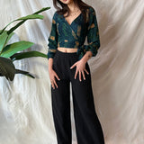 Woman wearing black pants and navy hand-dyed batik Brush Strokes print long sleeve wrap top by GEOMETRIC. 