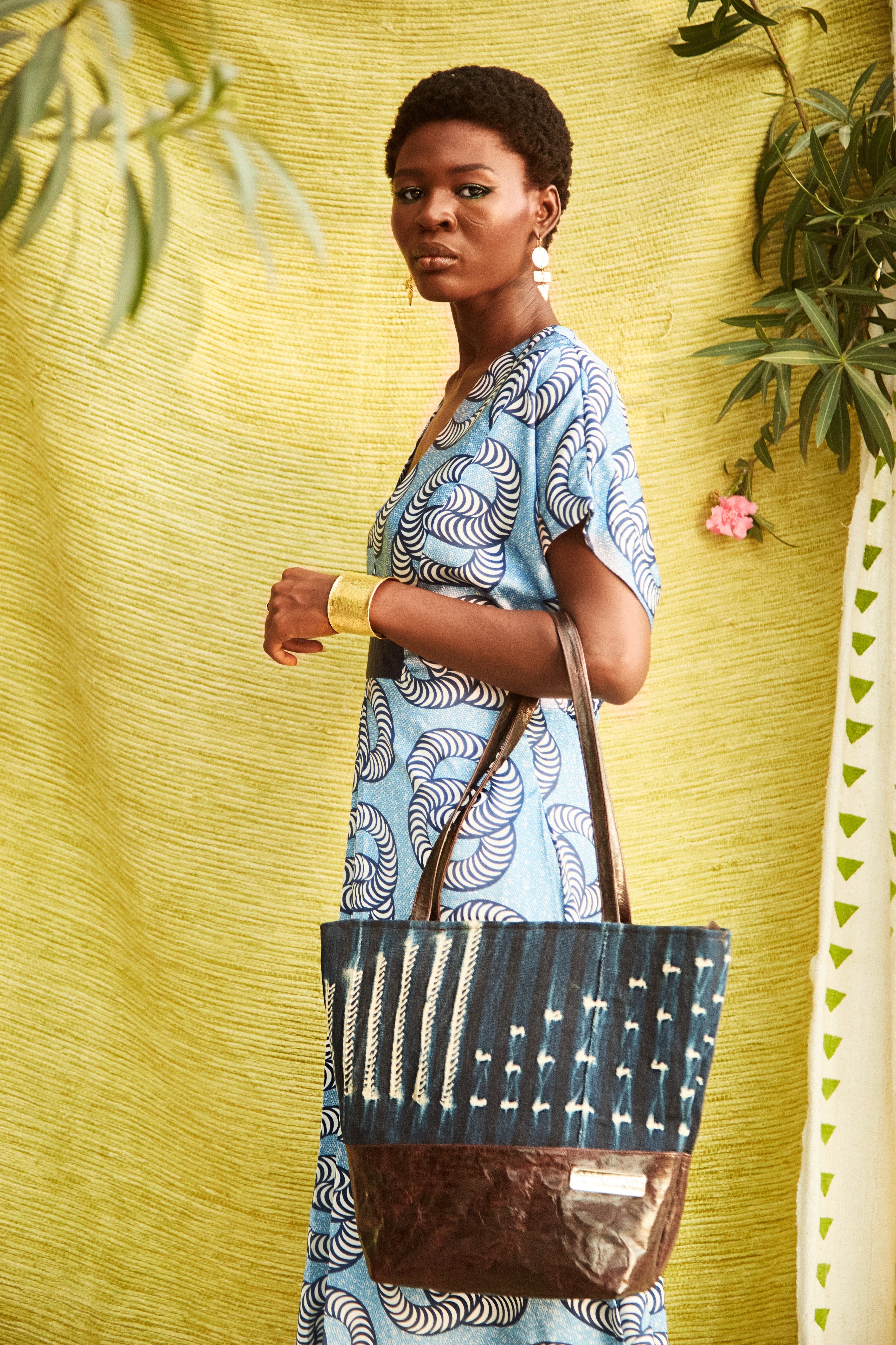 Woman holding Hand-dyed indigo fabric and leather Tema tote bag by GEOMETRIC. 